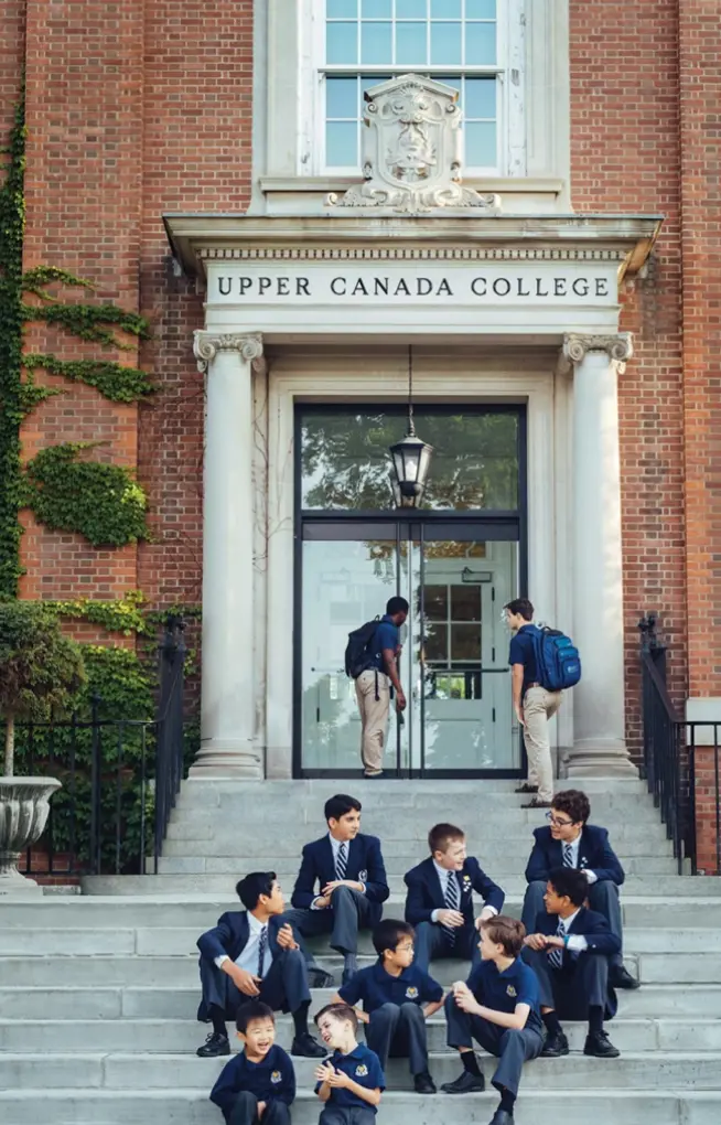 Students in uniforms gathered on the stone steps outside the historic Upper Canada College main entrance.